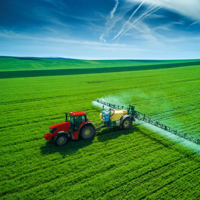 Green field being irrigated by a tractor