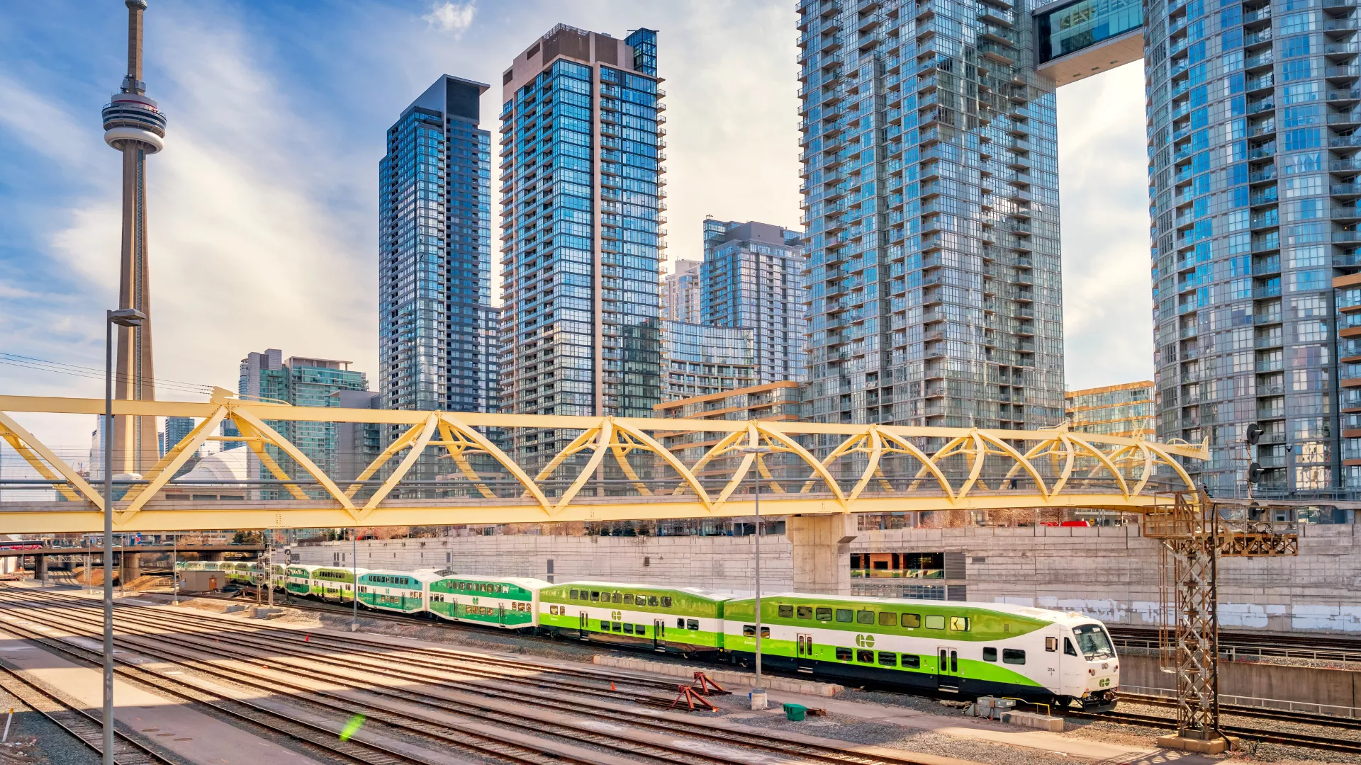 Go Train at a rail station with the Toronto skyline in the background