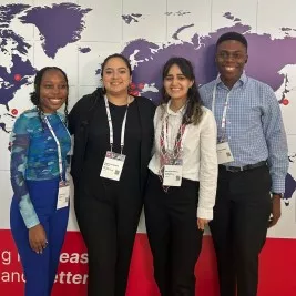 Four members of ISO/TC 207 Youth Leadership Group smiling at the ISO Annual Meeting on September 2024. 